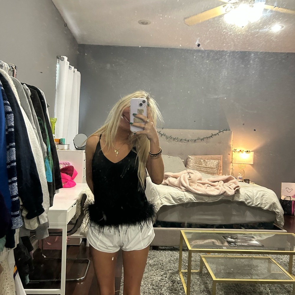 black tank top from a local boutique with black feathers around bottom